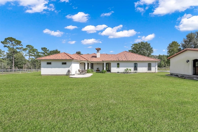 rear view of property with fence, stucco siding, and a lawn