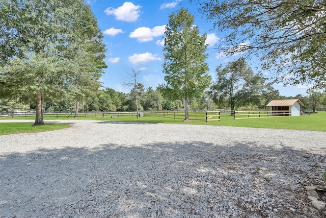 view of property's community with a yard, an outbuilding, and fence
