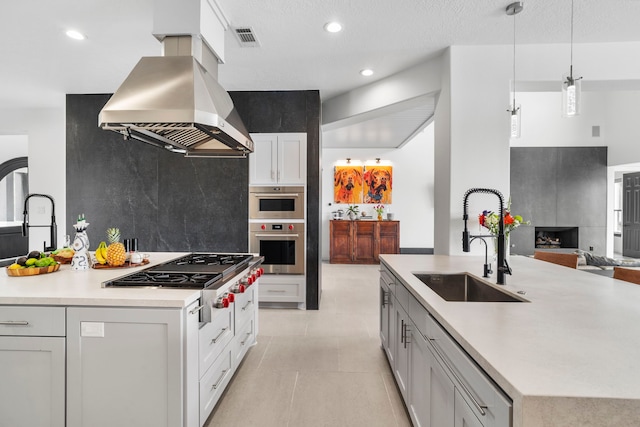 8603 Royal Retreat, Richmond, TX 77469 - kitchen featuring island exhaust hood, a sink, a kitchen island with sink, visible vents, and stainless steel gas stovetop