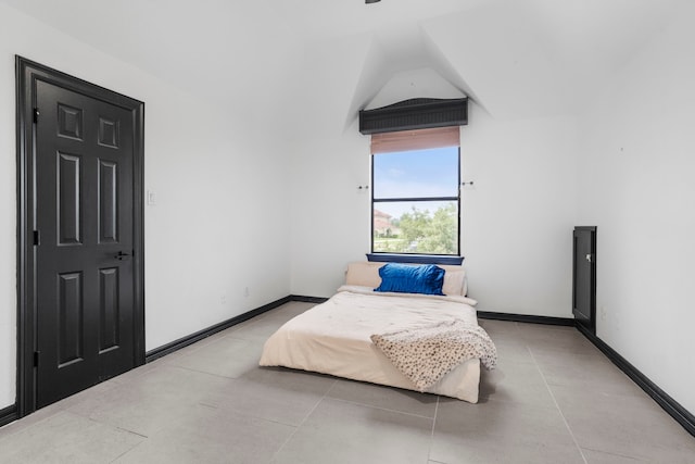 8603 Royal Retreat, Richmond, TX 77469 - bedroom featuring light tile patterned floors, vaulted ceiling, and baseboards