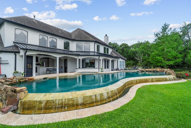 8603 Royal Retreat, Richmond, TX 77469 - back of house with a yard, an outdoor hot tub, an infinity pool, a patio area, and a standing seam roof