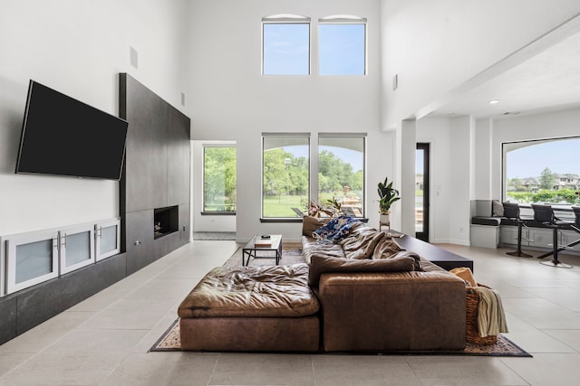8603 Royal Retreat, Richmond, TX 77469 - living area featuring light tile patterned floors, a tiled fireplace, and a high ceiling