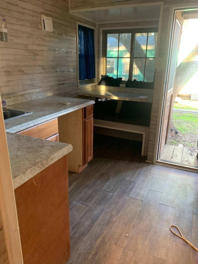 415 5th St, San Leon, TX 77539 - kitchen featuring brown cabinets, hardwood / wood-style floors, light countertops, and wooden walls