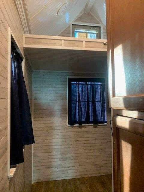 415 5th St, San Leon, TX 77539 - bathroom with vaulted ceiling, wooden walls, and wood finished floors