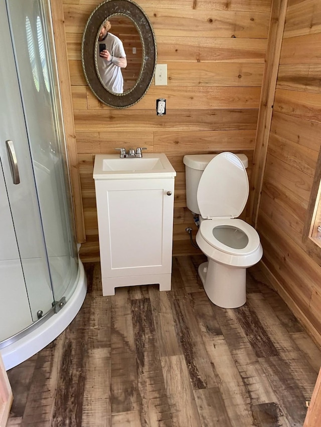 415 5th St, San Leon, TX 77539 - full bathroom with toilet, wood finished floors, a stall shower, wooden walls, and vanity