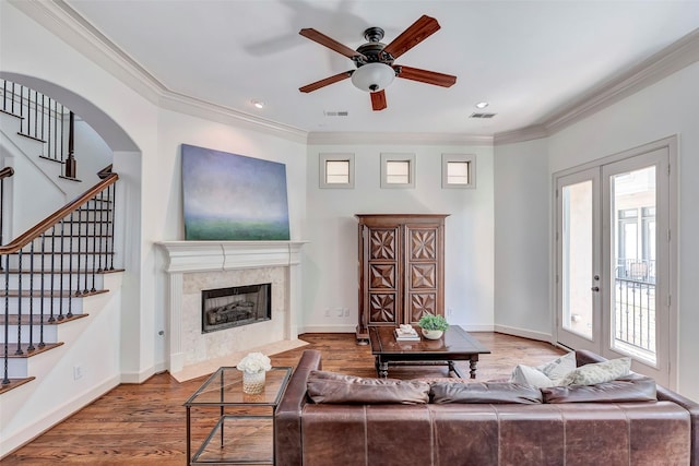 living room featuring ceiling fan, crown molding, a fireplace, and visible vents