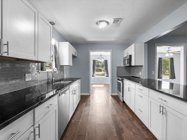 1922 Tracy Lynn Ln, Alvin, TX 77511 - kitchen with a sink, stainless steel appliances, dark wood-type flooring, decorative backsplash, and dark stone counters