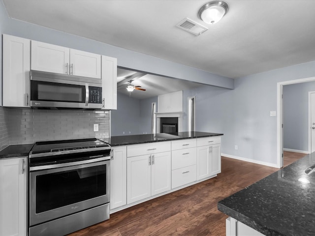 1922 Tracy Lynn Ln, Alvin, TX 77511 - kitchen featuring stainless steel appliances, ceiling fan, decorative backsplash, white cabinets, and dark wood-style flooring