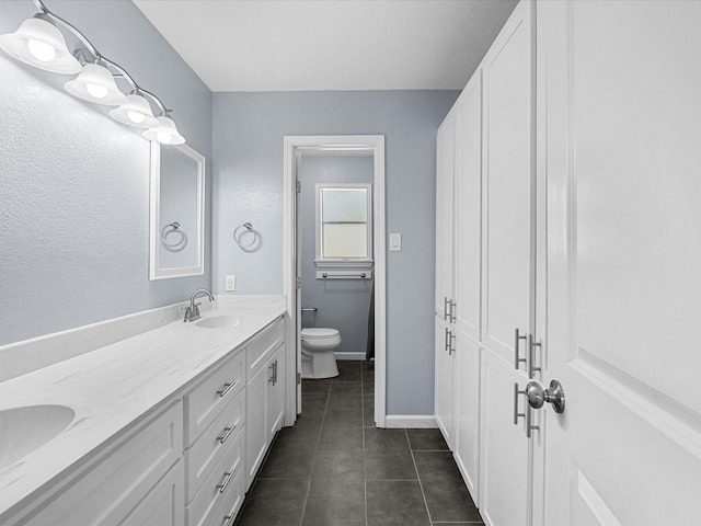 1922 Tracy Lynn Ln, Alvin, TX 77511 - bathroom featuring tile patterned flooring, toilet, double vanity, and baseboards