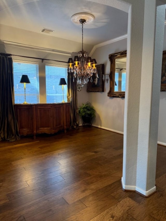 unfurnished dining area with ornamental molding, a chandelier, visible vents, and dark wood-style floors