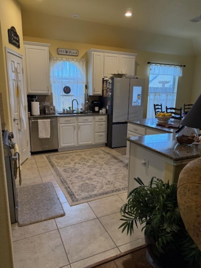 kitchen with light tile patterned flooring, visible vents, a sink, white cabinets, and appliances with stainless steel finishes