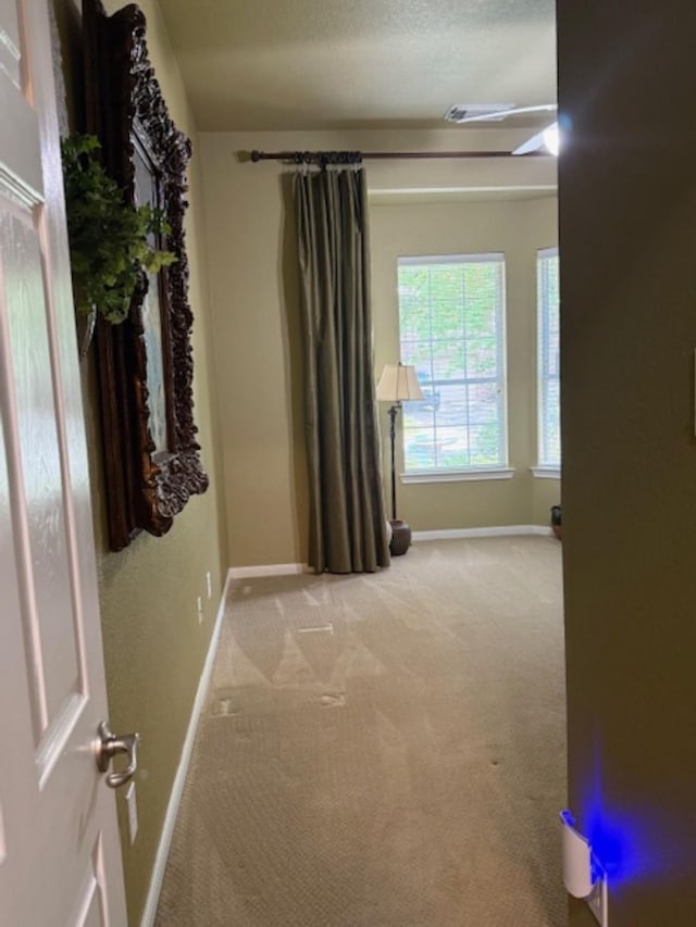 spare room with light colored carpet and baseboards