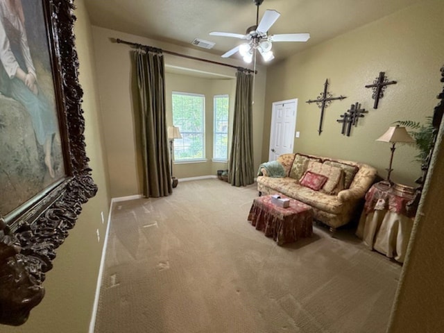 carpeted living area featuring baseboards, ceiling fan, and visible vents