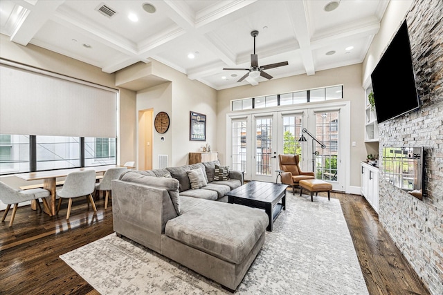 living room with a ceiling fan, coffered ceiling, beam ceiling, visible vents, and dark wood-type flooring