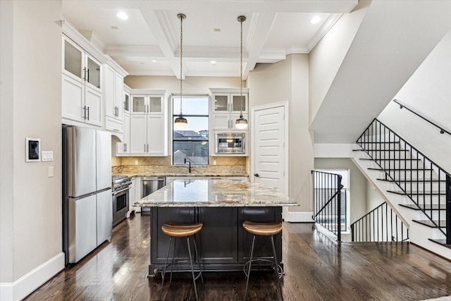 1214 Dunlavy St, Houston, TX 77019 - kitchen with appliances with stainless steel finishes, dark wood finished floors, a center island, beamed ceiling, and light stone counters