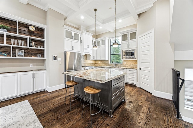 kitchen with coffered ceiling, stainless steel appliances, white cabinets, baseboards, and beamed ceiling