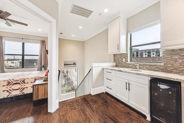 1214 Dunlavy St, Houston, TX 77019 - indoor bar with wine cooler, dark wood-style floors, tasteful backsplash, healthy amount of natural light, and ornamental molding