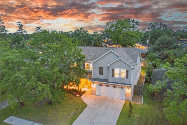 view of front of house featuring a shingled roof, concrete driveway, an attached garage, a front yard, and board and batten siding