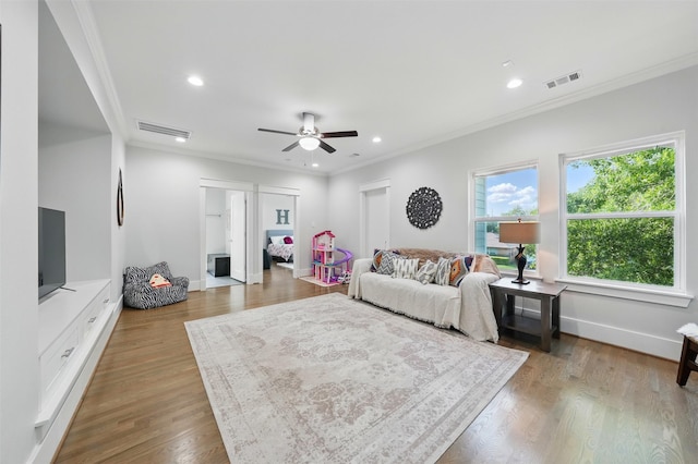 living area featuring ornamental molding, ceiling fan, recessed lighting, wood finished floors, and baseboards