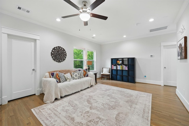 living area featuring ornamental molding, ceiling fan, wood finished floors, baseboards, and recessed lighting