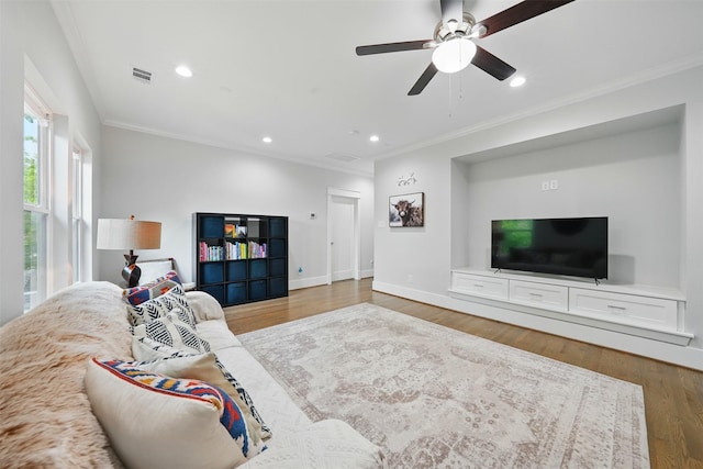 living room with crown molding, a ceiling fan, wood finished floors, baseboards, and recessed lighting
