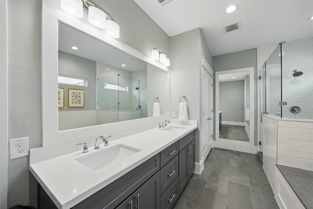 bathroom with a shower stall, double vanity, recessed lighting, and tile patterned floors