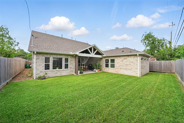 rear view of house featuring a patio area, brick siding, and a shingled roof