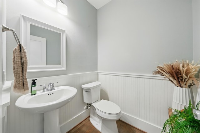 bathroom featuring wood finished floors and toilet