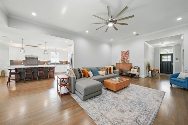 living area with ceiling fan, recessed lighting, wood finished floors, and crown molding