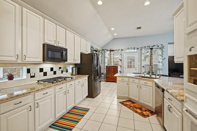 20714 Delta Wood Trl, Humble, TX 77346 - kitchen featuring black appliances, a sink, white cabinets, light tile patterned floors, and lofted ceiling