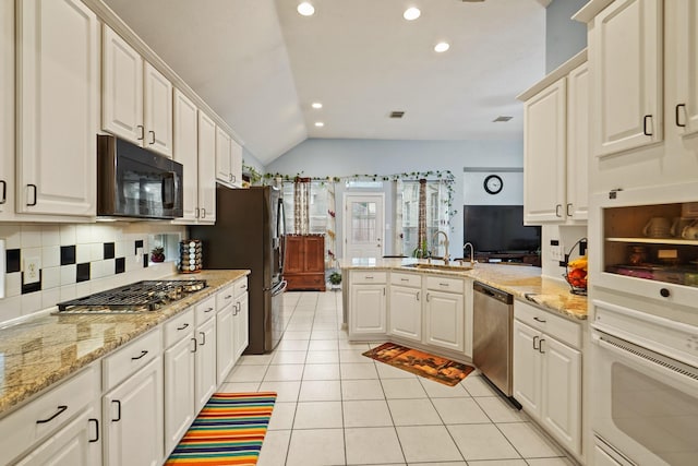 20714 Delta Wood Trl, Humble, TX 77346 - kitchen with stainless steel appliances, a sink, lofted ceiling, a peninsula, and recessed lighting