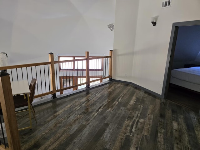 additional living space featuring baseboards, visible vents, and wood finished floors