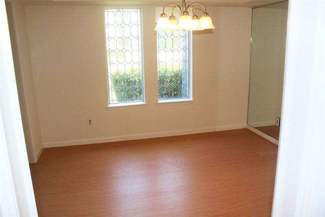 6103 Portal Dr, Houston, TX 77096 - empty room featuring wood finished floors, baseboards, and a chandelier