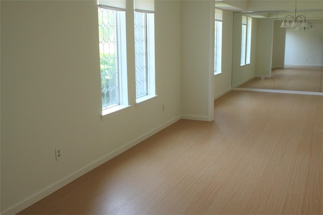 6103 Portal Dr, Houston, TX 77096 - spare room with baseboards, a chandelier, and light wood-style floors