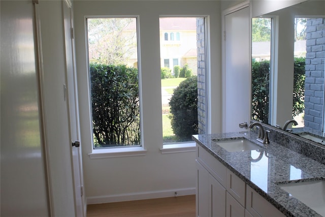 6103 Portal Dr, Houston, TX 77096 - bathroom with wood finished floors, baseboards, and double vanity