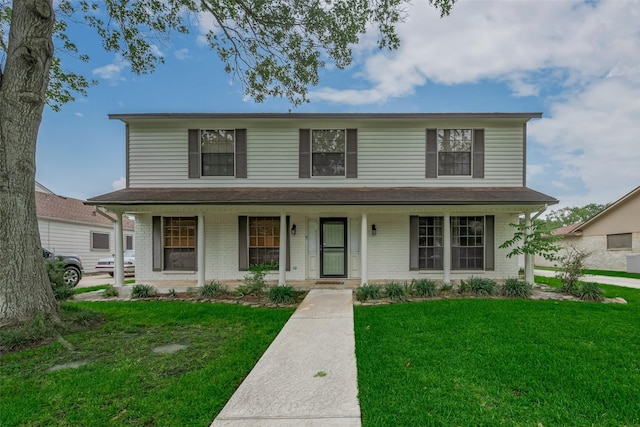view of front of property featuring a porch, a front yard, and brick siding