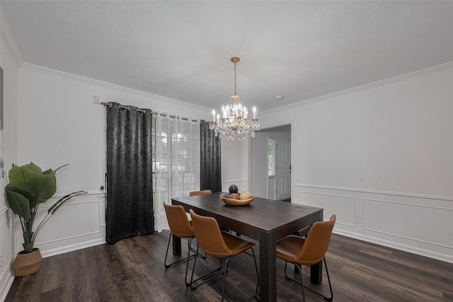 dining space featuring a chandelier, a decorative wall, dark wood-type flooring, crown molding, and wainscoting