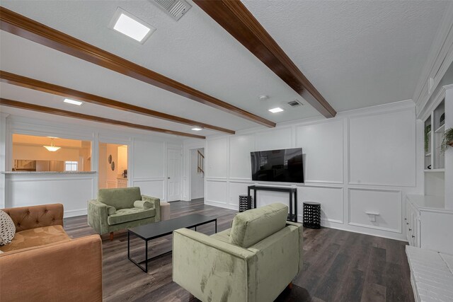living room with a decorative wall, beamed ceiling, dark wood-style floors, and ornamental molding