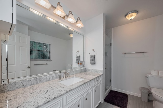 full bathroom featuring toilet, a shower stall, baseboards, vanity, and wood finished floors