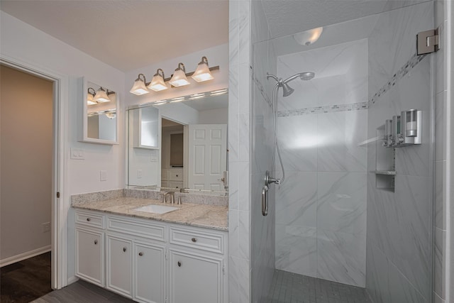 bathroom featuring a stall shower, vanity, and wood finished floors