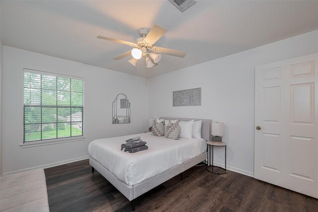 bedroom featuring dark wood-style flooring, baseboards, and a ceiling fan
