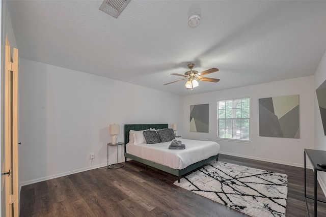 bedroom featuring dark wood-style flooring, baseboards, and ceiling fan