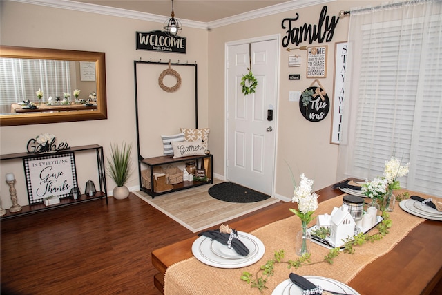 foyer entrance featuring ornamental molding, baseboards, and wood finished floors