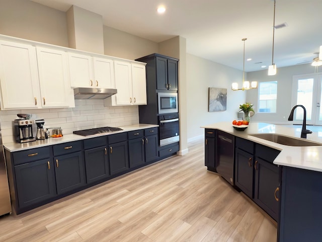 1438A Dian St, Houston, TX 77008 - kitchen featuring stainless steel appliances, under cabinet range hood, a sink, backsplash, and light countertops