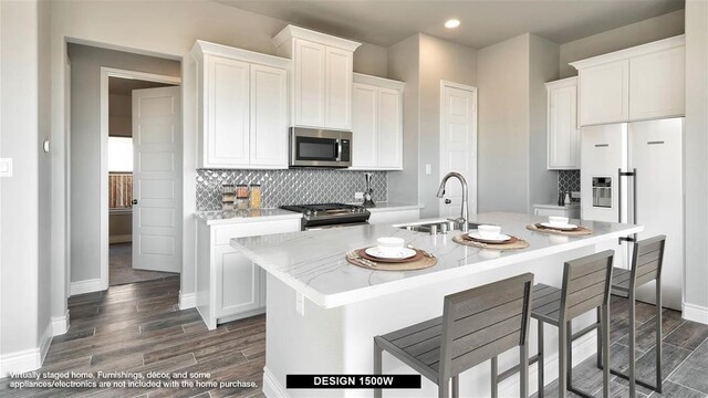 9714 Perdita Trl, Missouri City, TX 77459 - kitchen with range with gas cooktop, stainless steel microwave, a sink, dark wood-style flooring, and a center island with sink