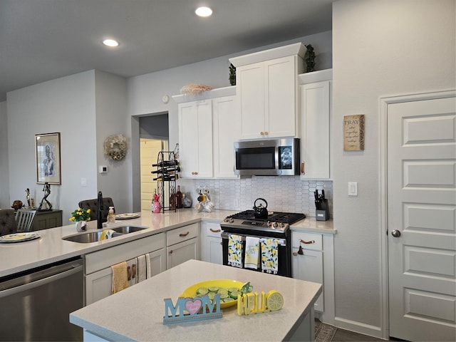 9714 Perdita Trl, Missouri City, TX 77459 - kitchen with appliances with stainless steel finishes, a sink, light countertops, white cabinetry, and tasteful backsplash