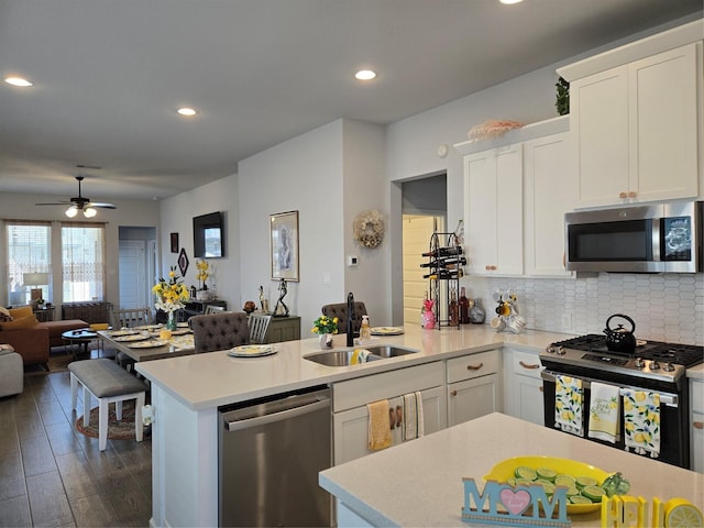 9714 Perdita Trl, Missouri City, TX 77459 - kitchen featuring appliances with stainless steel finishes, a sink, a peninsula, open floor plan, and light countertops