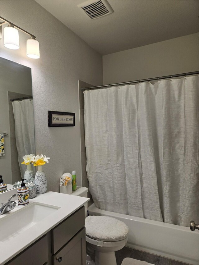 9714 Perdita Trl, Missouri City, TX 77459 - bathroom featuring shower / bathtub combination with curtain, vanity, toilet, and a textured wall