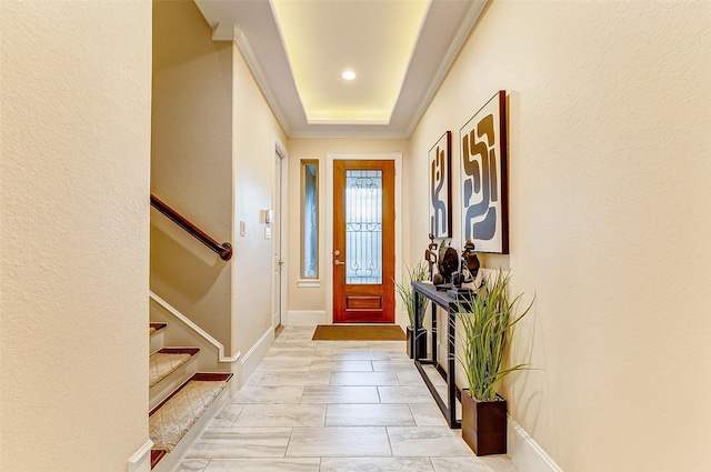 entryway featuring crown molding, stairs, and baseboards