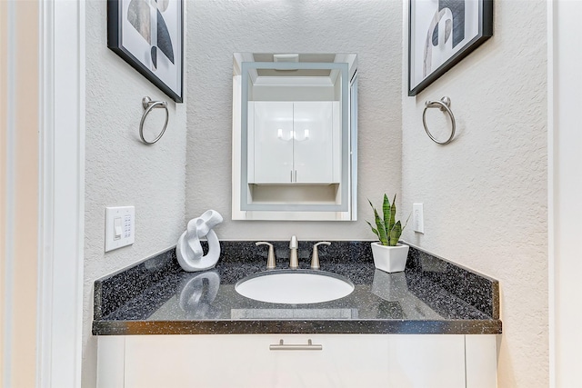 bathroom featuring vanity and a textured wall